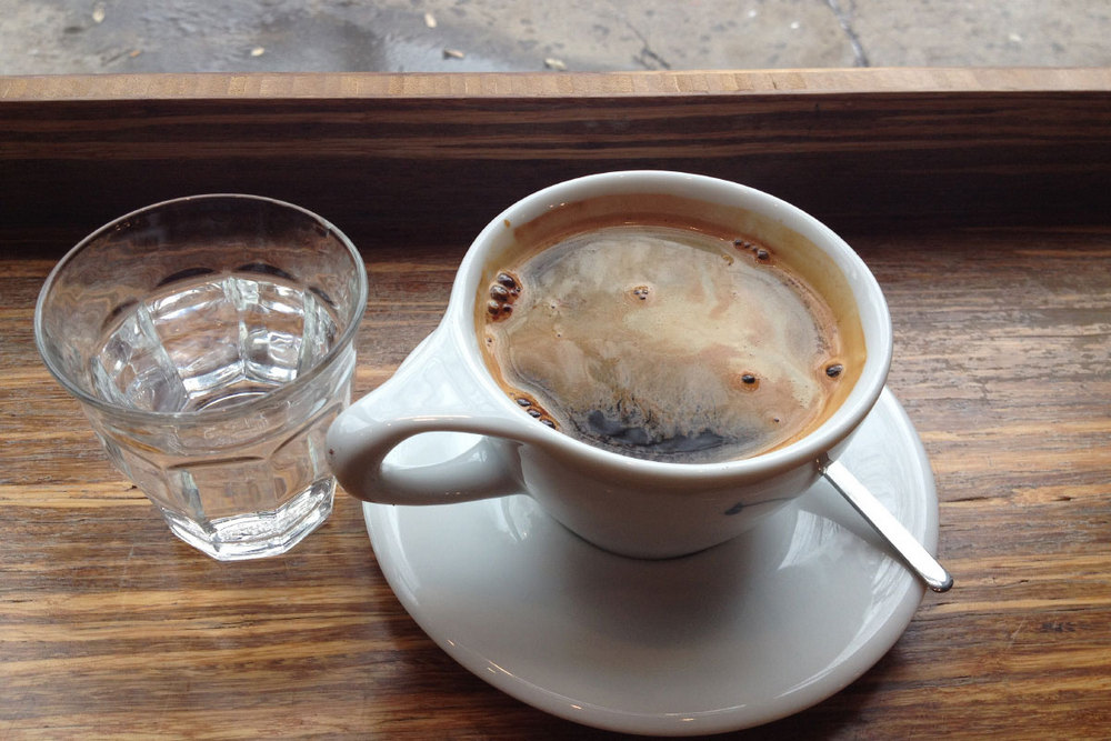 Кофе в чашке на блюдце и вода в стакане