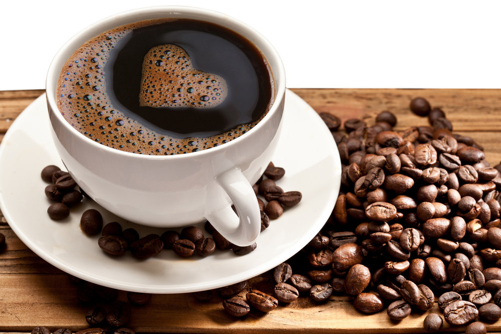Чашка с кофе на блюдце и кофейные зерна
