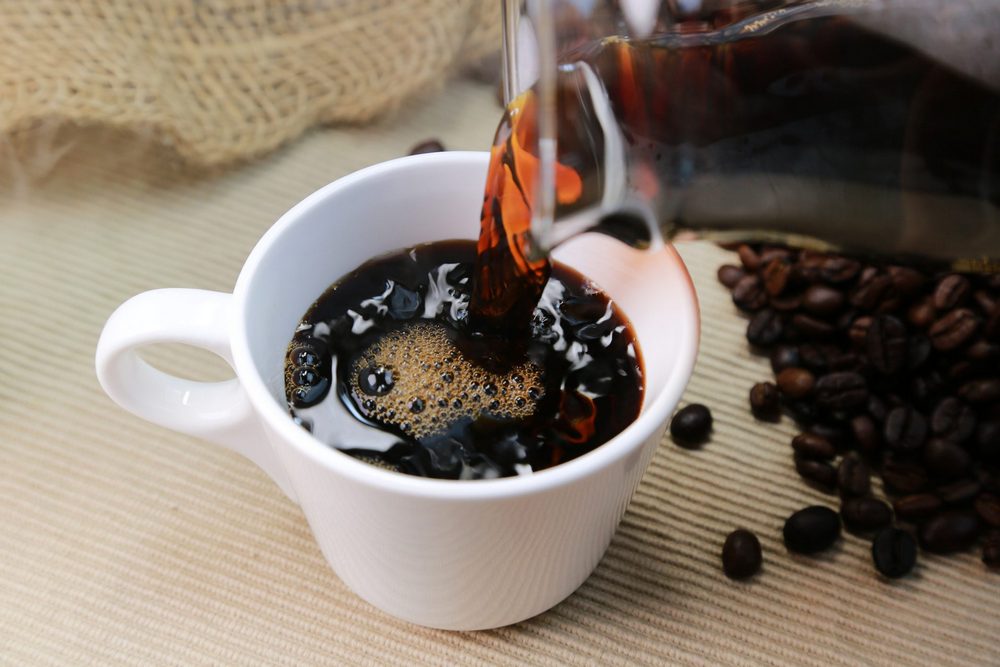 Черный кофе в чашке, кофейные зерена